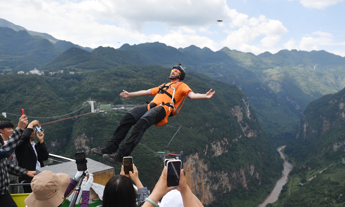 A foreign tourist takes a leap from a 520-meter-high platform at the Nizhu River Grand Canyon in Xuanwei, Qujing, Southwest China's Yunnan Province, on August 10, 2026. Located along the Yunnan-Guizhou border, the canyon has drawn summer visitors with adventure activities and sweeping views of the two provinces. Photo: VCG