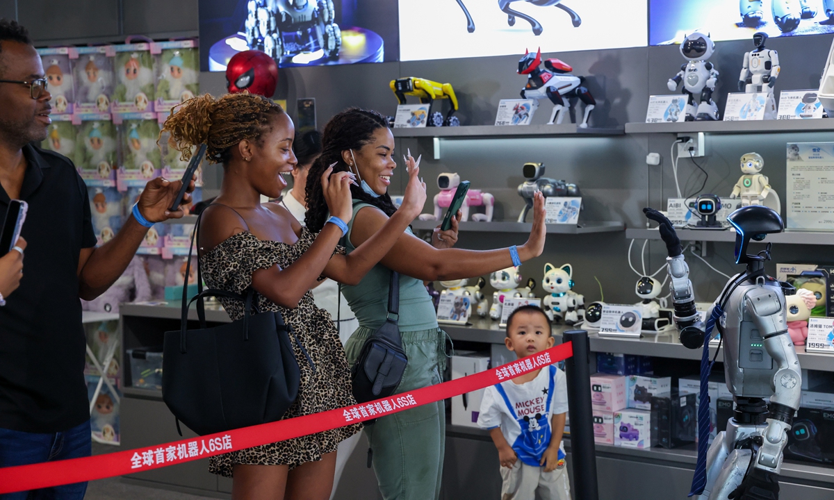 Photo released on August 9, 2026 shows tourists from Jamaica interacting with a humanoid robot at the world's first robot 6S store in Longgang District, Shenzhen, South China's Guangdong Province, on August 4. Photo: Xinhua