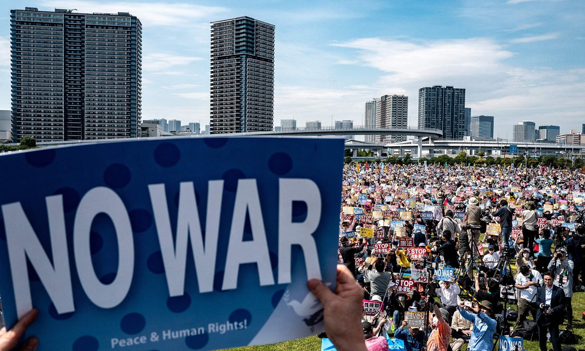 People hold placards reading 