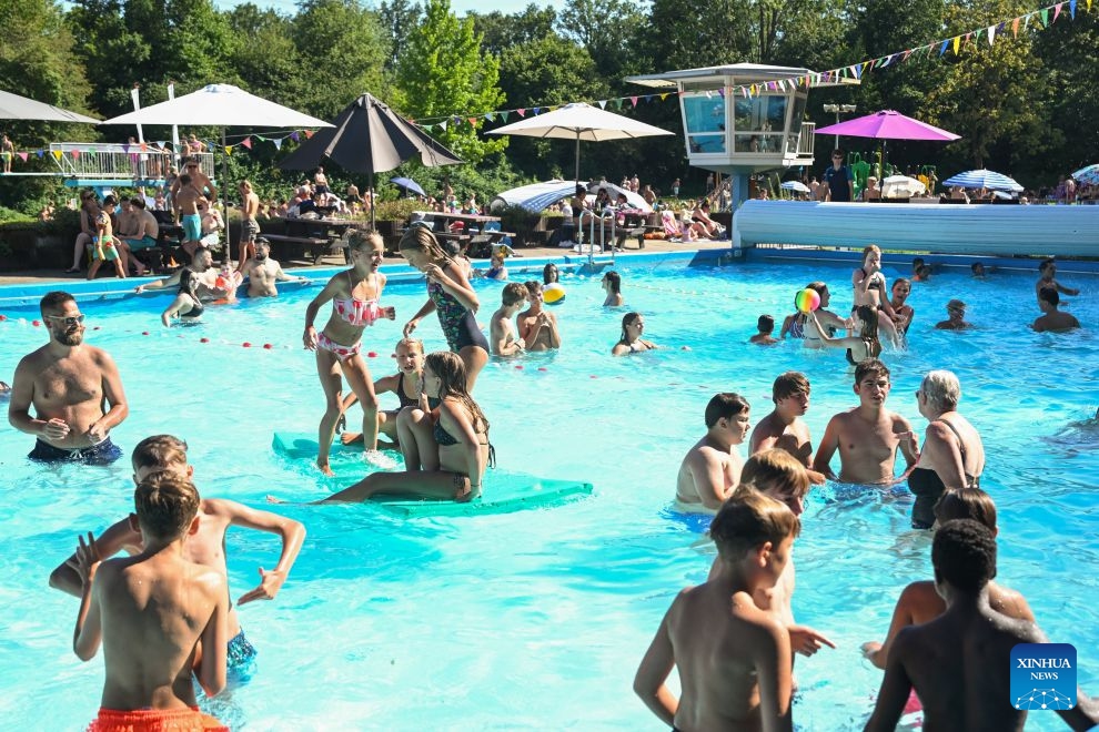 People cool off in an outdoor swimming pool in Delden, the Netherlands, Aug. 14, 2026. The Royal Netherlands Meteorological Institute (KNMI) issued a yellow heat warning on Aug. 14, 2026, as temperatures reached 35 degrees Celsius, marking the fifth heatwave in the Netherlands this year. (Photo: Xinhua)