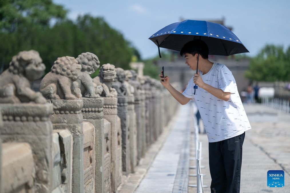 A man takes photos at the Lugou Bridge in Beijing, capital of China, Aug. 15, 2026. On July 7, 1937, Japanese soldiers attacked Chinese forces at the Lugou Bridge outside Wanping Town, marking the beginning of Japan's full-scale invasion of China, and China's whole-nation resistance against the Japanese invaders. People came to the Lugou Bridge cultural tourism area on Saturday on the occasion of the 81st anniversary of Japan's announcement of its unconditional surrender in World War II to commemorate the history. (Photo: Xinhua)