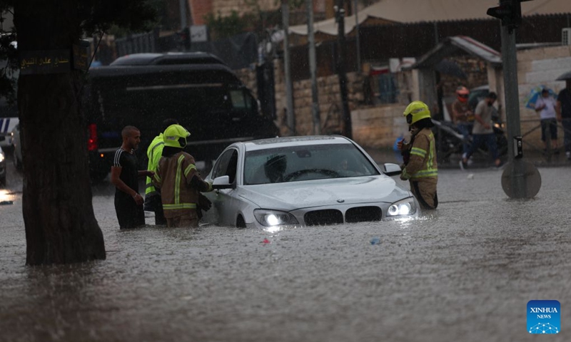 Rescuers try to help a stranded car out of a flooded road in Jerusalem, Aug. 15, 2026. Rare heavy downpours trigger mountain flash floods and urban waterlogging across Jerusalem on Saturday. The region is currently in midsummer, a period typically marked by extreme drought and almost zero precipitation. (Photo: Xinhua)