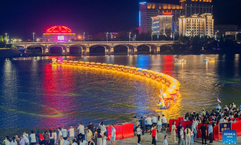 Tourists watch a golden dragon parade at Dayong Ancient Town in Zhangjiajie, central China's Hunan Province, Aug. 14, 2026. Leveraging its rich intangible cultural heritage, the city of Zhangjiajie has developed diverse summer getaways and multiple forms of night tours, fueling a travel boom during the peak season. (Photo: Xinhua)
