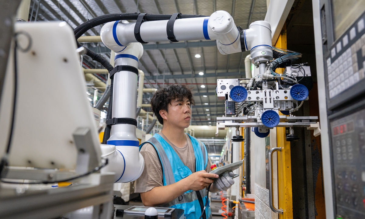 A technician monitors as robots work at a manufacturing facility in Huzhou, East China's Zhejiang Province, on August 11, 2026. The facility employs AI-powered visual sensing technology to optimize automated production and enable round-the-clock coordinated operations. Photo: VCG