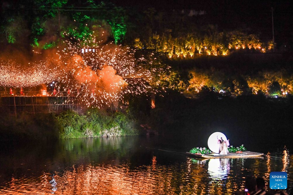 A dance and a molten iron firework performance are staged together during a tourism and culture festival themed on floating lanterns for the Qixi Festival, also known as Chinese Valentine's Day, in Rongchang District of southwest China's Chongqing Municipality, Aug. 15, 2026. The tourism and culture festival kicked off here on Saturday, featuring a concert, a parade and various performances including molten iron fireworks and bamboo raft shows. (Photo: Xinhua)