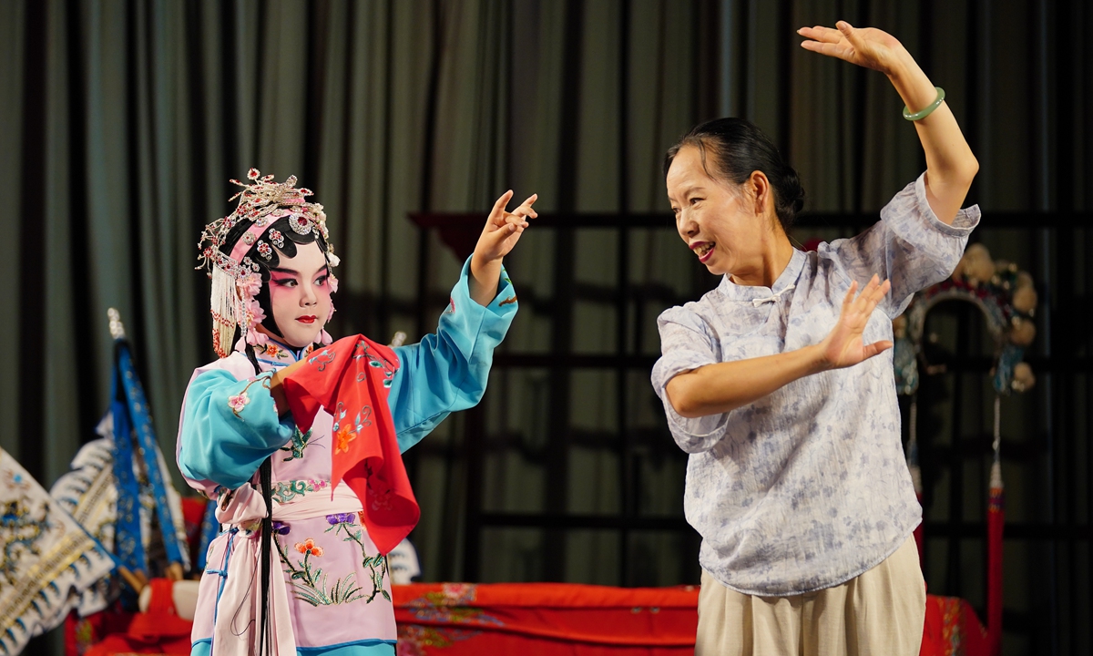 A child (left) learns the movements of Dian Opera under the guidance of a teacher at a Dian Opera museum in Kunming, Southwest China's Yunnan Province, on August 13, 2026. The museum has introduced immersive experiences that allow visitors to choose roles, try on costumes and learn Dian Opera singing and movements. Photo: VCG