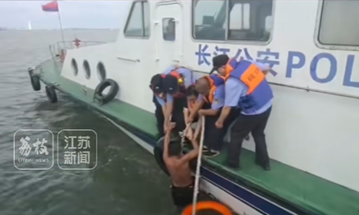 A man in East China's Jiangsu Province who recently tried to swim across the Yangtze River to Shanghai to save travel costs is rescued by police. Photo: Screenshot from Jiangsu TV