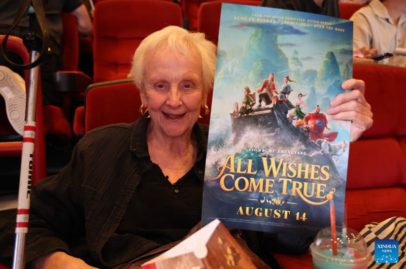 A moviegoer holds a poster for the Chinese animated film All Wishes Come True at its North American premiere in Los Angeles, California, the United States, Aug. 13, 2026. Chinese animated fantasy-comedy All Wishes Come True held its North American premiere Thursday night in Los Angeles, ahead of its theatrical release across the United States and Canada on Friday. (Photo by Zeng Hui/Xinhua)