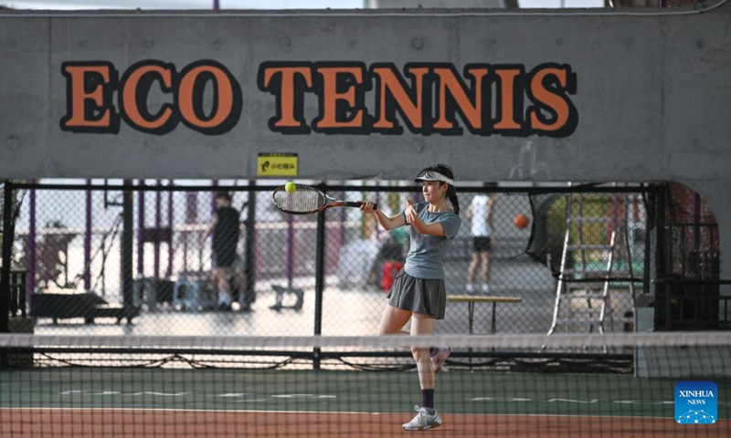 A woman plays tennis under a bridge in Liangjiang New Area, southwest China's Chongqing, Aug. 10, 2026. In recent years, Liangjiang New Area has transformed vacant spaces under bridges into spaces for exercise and recreation. Photo: Xinhua