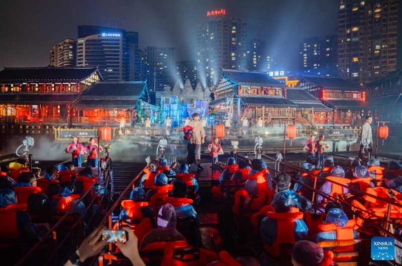 Audience watch Changde Memories, a large-scale immersive performance, at Hejie leisure district in Changde, central China's Hunan Province, on Aug. 13, 2026. Hejie is a riverside leisure district combining tourism, recreation, vacation experience and residential use. Since 2025, the district has launched Changde Memories, a large-scale immersive site-specific performance featuring light shows, the history of river transport, and stories of local intangible cultural heritage. To date, the performance has attracted more than 50,000 visits, helping boost local spending. Photo: Xinhua
