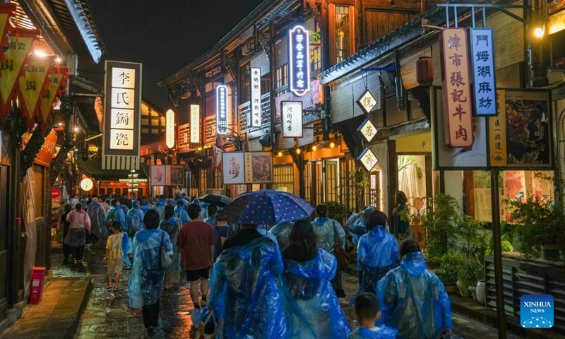 Audience move between different areas during the performance of Changde Memories, a large-scale immersive performance, at Hejie leisure district in Changde, central China's Hunan Province, on Aug. 13, 2026. Hejie is a riverside leisure district combining tourism, recreation, vacation experience and residential use. Since 2025, the district has launched Changde Memories, a large-scale immersive site-specific performance featuring light shows, the history of river transport, and stories of local intangible cultural heritage. To date, the performance has attracted more than 50,000 visits, helping boost local spending. Photo: Xinhua