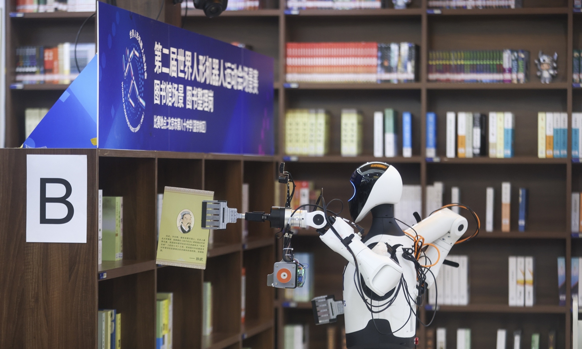 A humanoid robot inspects a bookshelf during a library scenario competition at the 2nd World Humanoid Robot Games in Beijing on August 16, 2026. Photo: VCG