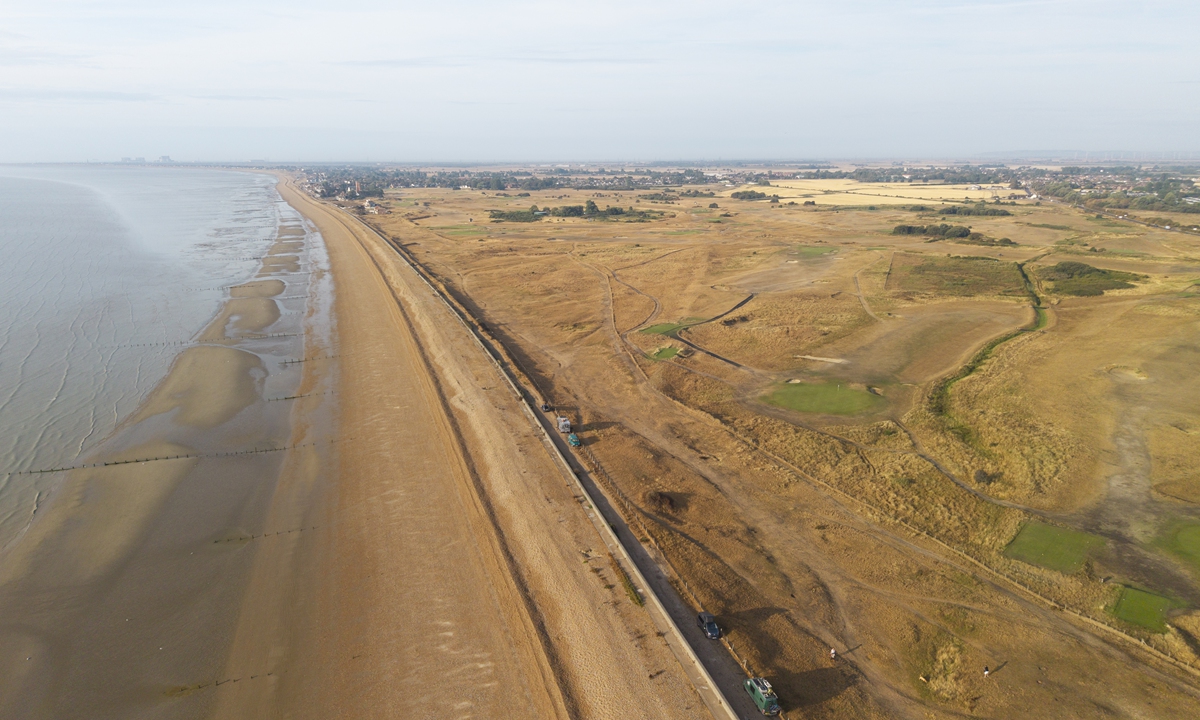 An aerial view of parched fields and a golf course beside the beach on August 17, 2026, in St. Marys Bay, England. The National Drought Group has declared that two-thirds of England is officially in drought, with water-use restrictions impacting 27 million people. Photo: VCG