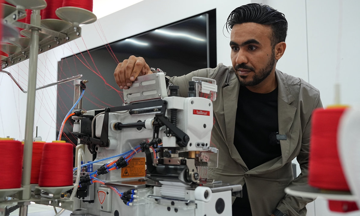 Al-Fosaiel Khaled Abdulatef Ahmed, head of Taizhou Tailleur Sewing Equipment Co, fine-tunes a sewing machine developed by the company. (Photo/Gao Ankang)