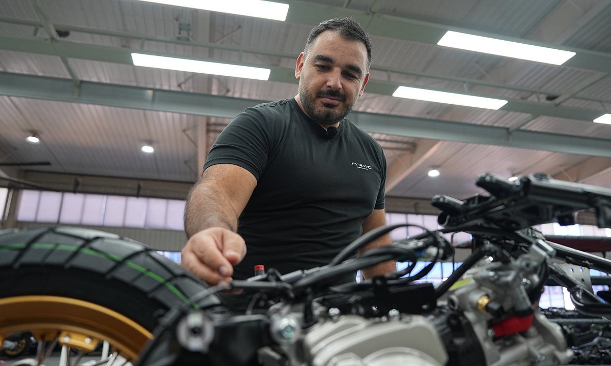 Argentine designer Rodrigo Alvarez fine-tunes a motorcycle on the production line at Jinlang Science & Technology Co in Taizhou, East China's Zhejiang Province. (Photo/Gao Ankang)