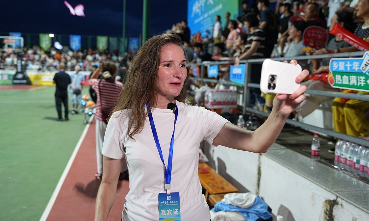 Taizhou overseas communications ambassador Pan Moli films a promotional video at a village basketball league game in Baishuiyang town, Linhai, a county-level city administered by Taizhou, East China's Zhejiang Province. (Photo/Gao Ankang)