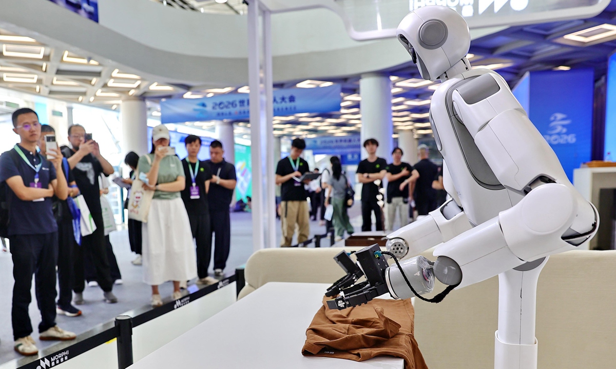 Visitors watch a robot folding clothes at the 2026 World Robot Conference in Beijing, August 19, 2026. Photo: VCG