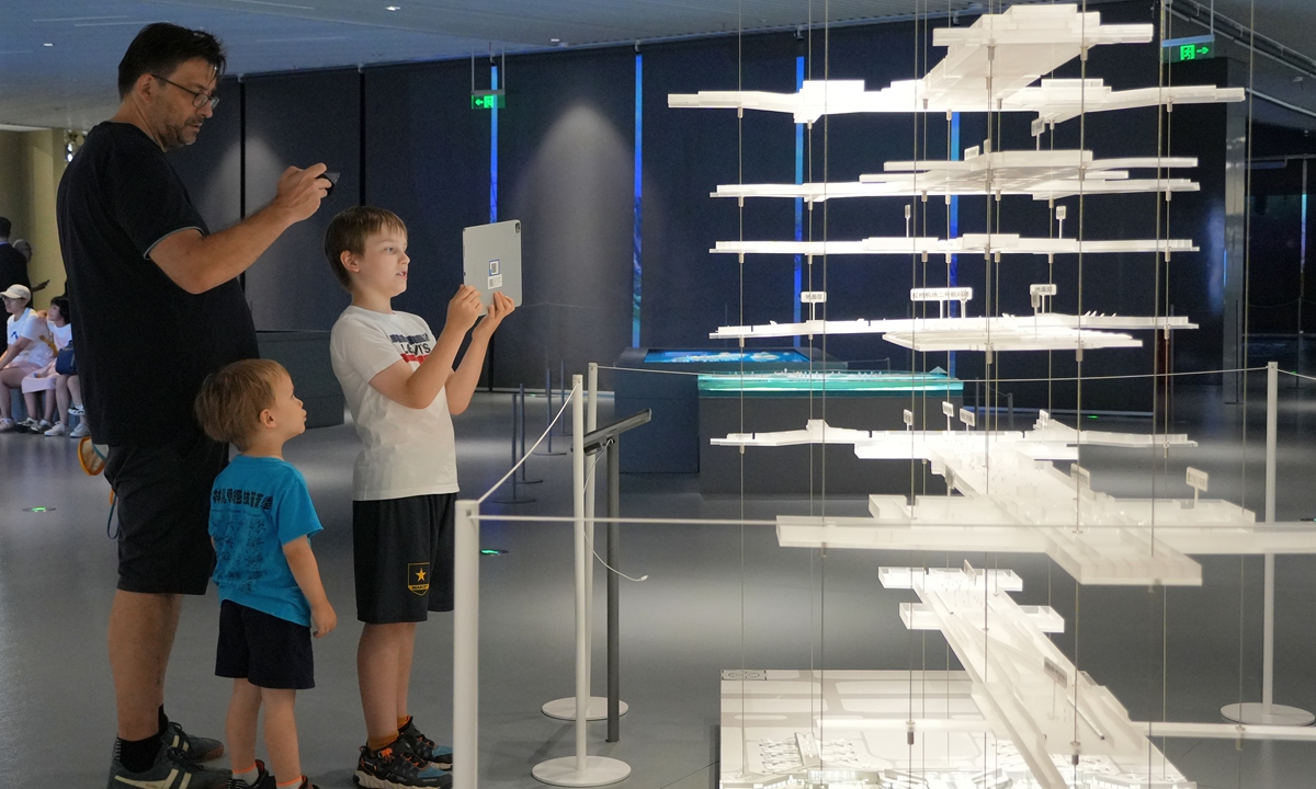 Foreign tourists view a model of urban planning and construction at the Shanghai Urban Planning Exhibition Center on August 10, 2025. Photo: VCG