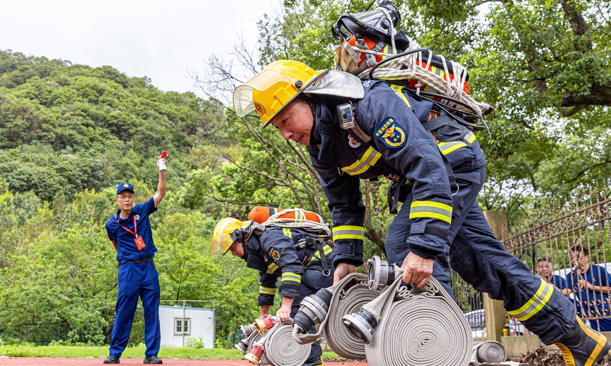 Firefighters compete in a fire hose connection drill at a training base in Chengnan township, Wenling, East China's Zhejiang Province on August 20, 2026. Photo: VCG