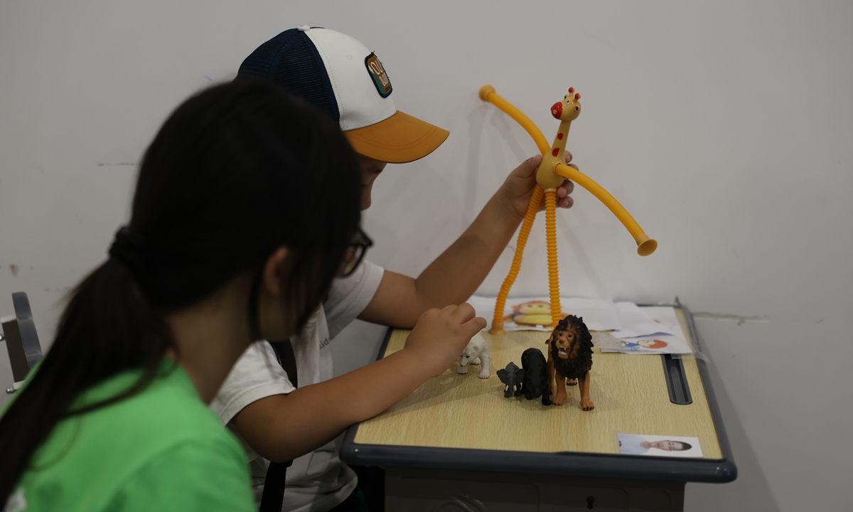 Accompanied by a volunteer, a child with autism plays toys at Palm Star Children's Rehabilitation Service Center in Shanghai on July 30, 2026. Photo: Chen Xia/GT