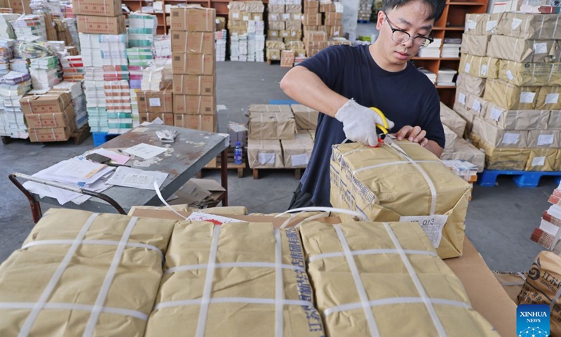 A staff member sorts out textbooks for the upcoming new semester in Haimen District of Nantong, east China's Jiangsu Province, on Aug. 20, 2026. Various departments across the country are getting ready for the upcoming new semester. (Photo by Xu Congjun/Xinhua)