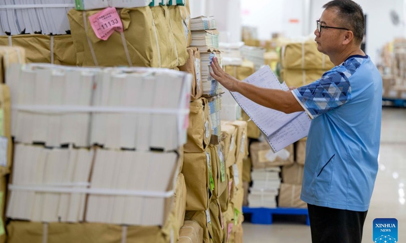 A staff member checks the textbooks for the upcoming new semester at a delivery center in Wuzhou, south China's Guangxi Zhuang Autonomous Region, on Aug. 21, 2026. Various departments across the country are getting ready for the upcoming new semester. (Photo by He Huawen/Xinhua)