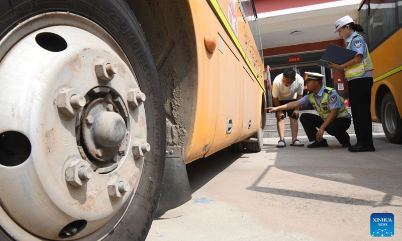 Traffic police officers inspect school buses at a primary school in Guangping County of Handan, north China's Hebei Province, on Aug. 21, 2026. Various departments across the country are getting ready for the upcoming new semester. (Photo by Cheng Xuehu/Xinhua)