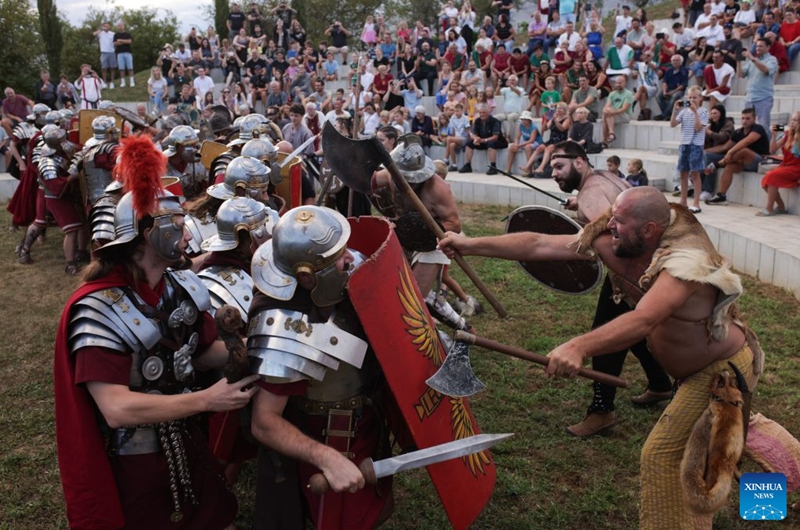 Participants dressed as Roman soldiers and barbarians demonstrate a battle during the Roman Games Festival in Ptuj, Slovenia, Aug. 22, 2026. The 19th edition of the Roman Games festival kicked off on Friday in Ptuj and will last till Aug. 23. (Photo by Zeljko Stevanic/Xinhua)