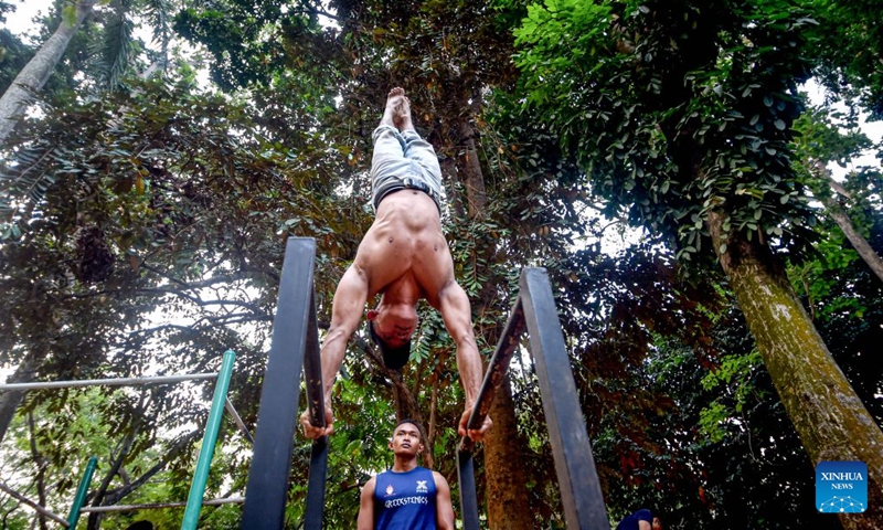 Members of a calisthenic community practice street workouts with simple iron bars at a public park in South Tangerang, Banten Province, Indonesia, Aug. 22, 2026. (Xinhua/Agung Kuncahya B.)