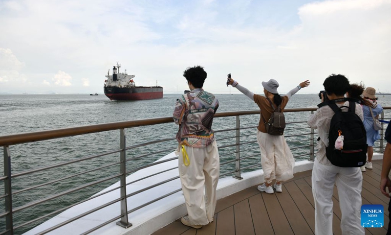 Visitors take photos aboard the cruise ship Da Wan Qu Yi Dun, Aug. 22, 2026. Named after the Greater Bay Area, known in Chinese as Da Wan Qu, the cruise ship Da Wan Qu Yi Dun departed from the Nansha International Cruise Home Port in Guangzhou on Saturday, marking the official launch of the regular Guangzhou-Shenzhen maritime cultural tourism route.
Sailing past the Hong Kong-Zhuhai-Macao Bridge, the Shenzhen-Zhongshan Link and 16 landmarks of the Greater Bay Area, the ship also provided visitors with diverse onboard experiences including performances themed on intangible cultural heritage and magic shows. Photo: Xinhua