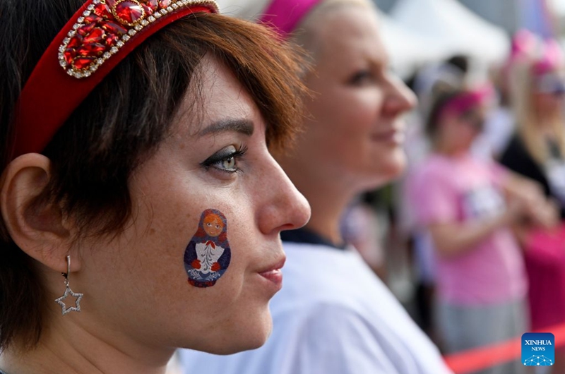 A woman with a print of Matryoshka, Russian traditional doll, on her face attends the Russian Field Art Festival at Victory Park in Moscow, Russia, on Aug. 22, 2026. The 15th Russian Field Art Festival kicked off at Victory Park in Moscow, Russia, on Aug. 22. (Photo by Alexander Zemlianichenko Jr/Xinhua)