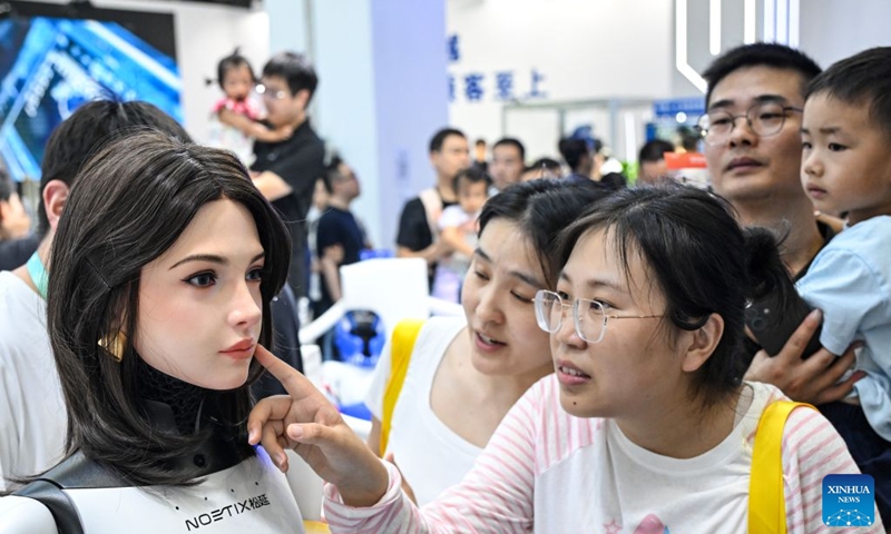 People view a humanoid robot at the 2026 World Robot Conference in Beijing, capital of China, Aug. 22, 2026. The conference, which runs from Wednesday through Sunday, has drawn more than 300 exhibitors from 26 countries, with over 3,000 products on display, including more than 300 debuts. Many people visited the conference on Saturday, the first open day of the event. Photo: Xinhua