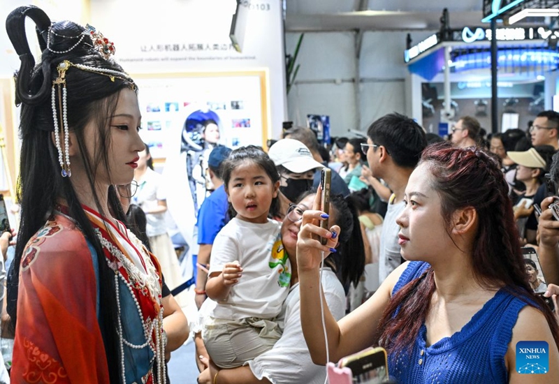 People view a humanoid robot at the 2026 World Robot Conference in Beijing, capital of China, Aug. 22, 2026. The conference, which runs from Wednesday through Sunday, has drawn more than 300 exhibitors from 26 countries, with over 3,000 products on display, including more than 300 debuts. Many people visited the conference on Saturday, the first open day of the event. Photo: Xinhua