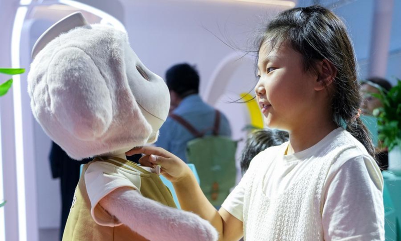 A child interacts with a companion robot during the 2026 World Robot Conference in Beijing, capital of China, Aug. 20, 2026. (Xinhua/Ju Huanzong)