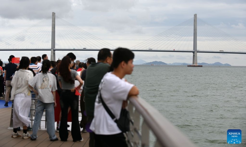 Visitors take a look at the Hong Kong-Zhuhai-Macao Bridge aboard the cruise ship Da Wan Qu Yi Dun, Aug. 22, 2026. Named after the Greater Bay Area, known in Chinese as Da Wan Qu, the cruise ship Da Wan Qu Yi Dun departed from the Nansha International Cruise Home Port in Guangzhou on Saturday, marking the official launch of the regular Guangzhou-Shenzhen maritime cultural tourism route.
Sailing past the Hong Kong-Zhuhai-Macao Bridge, the Shenzhen-Zhongshan Link and 16 landmarks of the Greater Bay Area, the ship also provided visitors with diverse onboard experiences including performances themed on intangible cultural heritage and magic shows. Photo: Xinhua