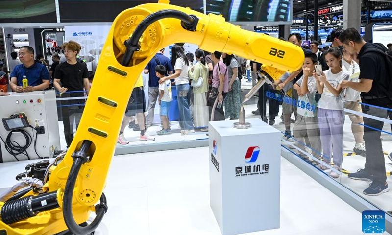 People view an industrial robot at the 2026 World Robot Conference in Beijing, capital of China, Aug. 22, 2026. The conference, which runs from Wednesday through Sunday, has drawn more than 300 exhibitors from 26 countries, with over 3,000 products on display, including more than 300 debuts. Many people visited the conference on Saturday, the first open day of the event. Photo: Xinhua