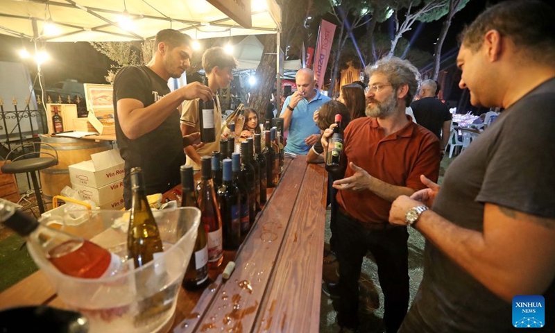 People learn about information of wine from exhibitors at the 9th edition of the Bois de Boulogne wine festival in Bolonia village, Mount Lebanon, Lebanon, Aug. 21, 2026. (Xinhua/Bilal Jawich)