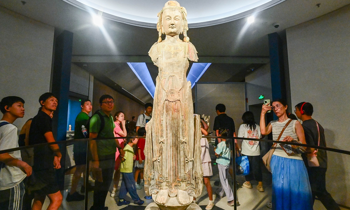 Tourists observe a Buddhist statue at the Qingzhou Museum in Qingzhou, East China's Shandong Province, on August 23, 2026. The famed Buddhist statues from the Longxing Temple hoard in Qingzhou are celebrated for their subtle 