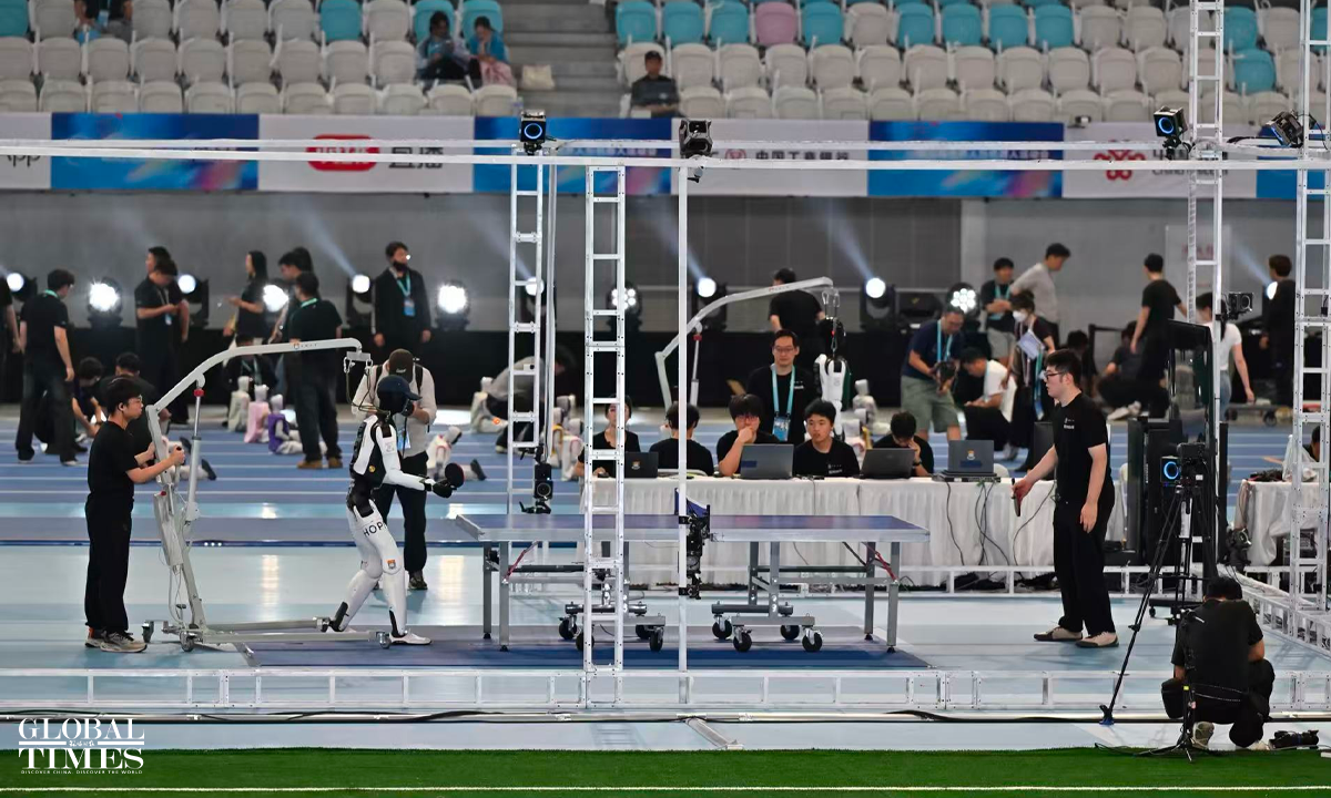 A humanoid robot and a human athlete demonstrate table tennis match at the National Speed Skating Oval in Beijing on August 22, 2026. Photo: Tao Mingyang/GT