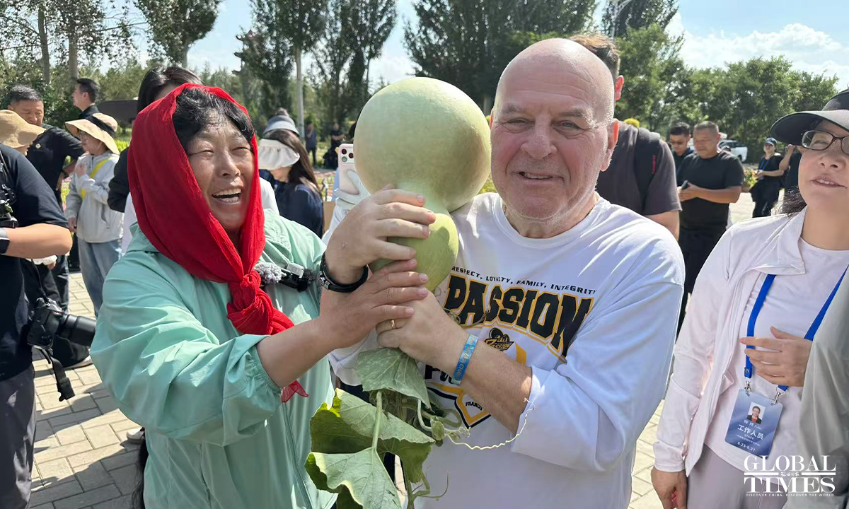 Yin Yunzhen introduces to Sakolsky the harvest from the once-barren wasteland. Photo: Lin Xiaoyi/GT