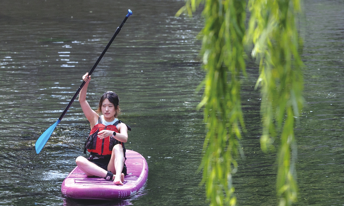 People are having fun with recreational sports along the North Moat near Deshengmen in Beijing. Photos: Li Hao/GT A woman paddleboards down a river in Beijing. 
