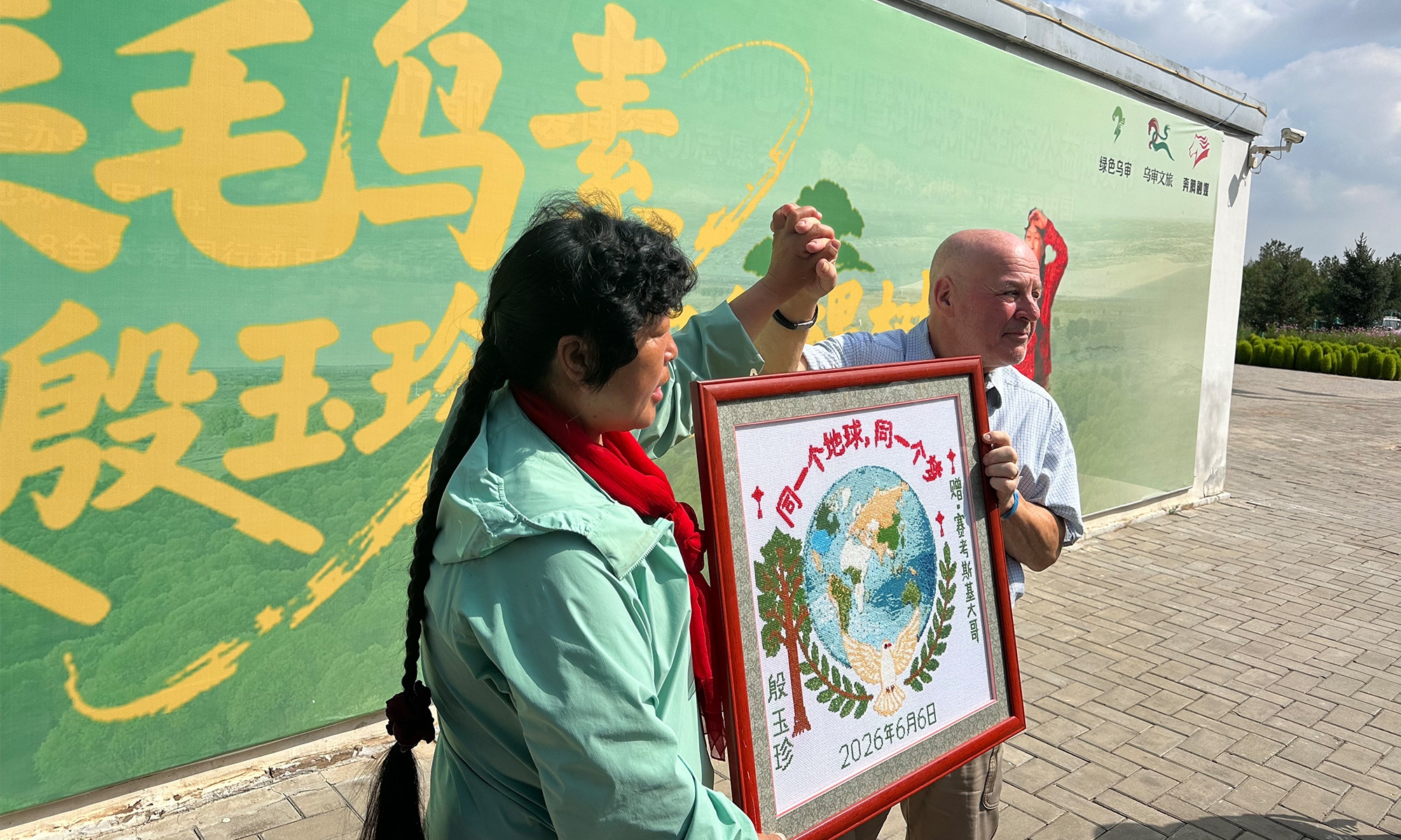 Yin Yuzhen (left) and Ronald Sakolsky pose for a photo with the cross-stitch embroidery gift presented by Yin, on August 25, 2026. Photo: Lin Xiaoyi/GT