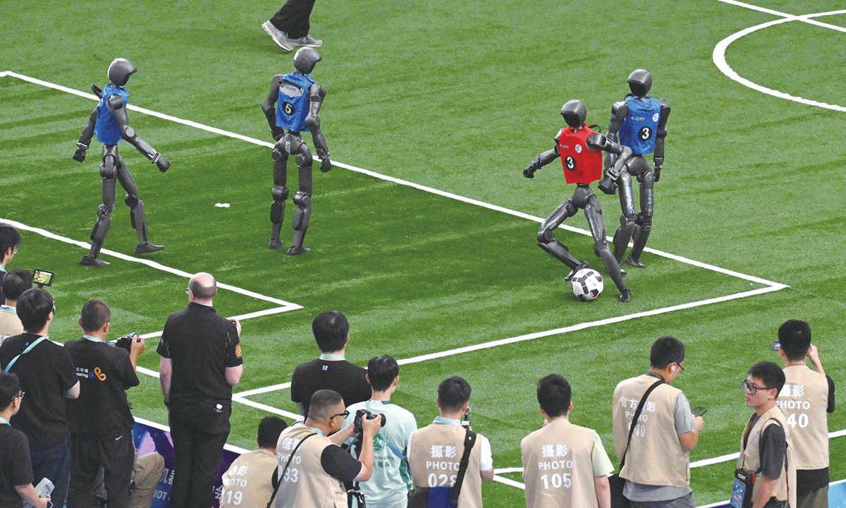 Humanoid robots compete for the ball during the final of the large-scale robot soccer event at the 2nd World Humanoid Robot Games at the National Speed Skating Oval. The 2nd World Humanoid Robot Games conclude on August 26, 2026 with several highlighting final matches. Photo: VCG