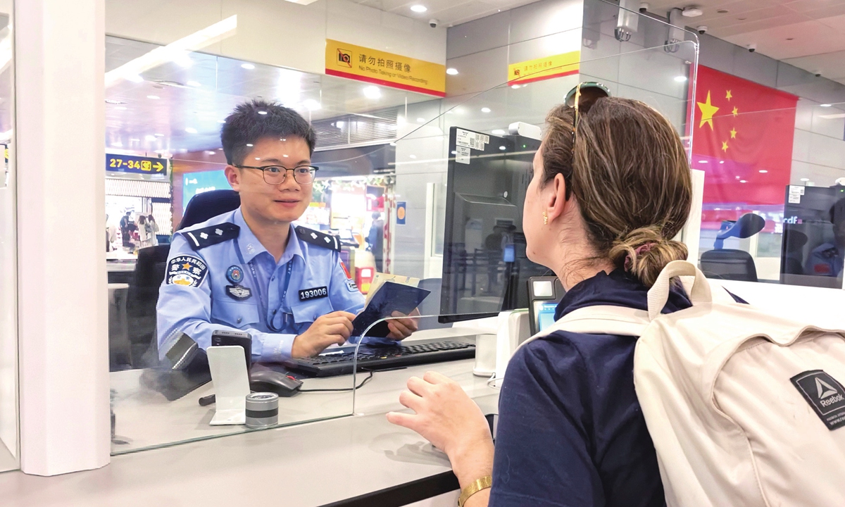 An immigration officer checks documents of an inbound passenger at Shanghai Pudong International Airport. Photo: Courtesy of Shanghai General Station of Immigration Inspection