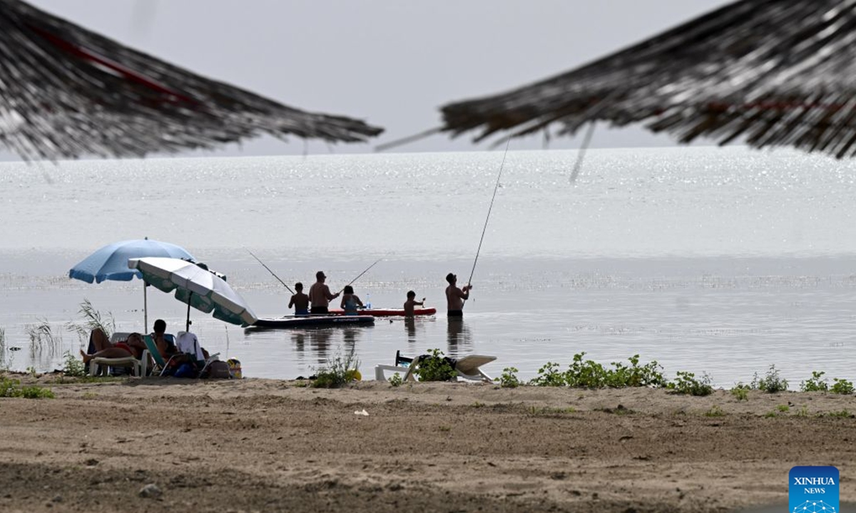 People enjoy themselves at the shore of Prespa Lake, Resen, North Macedonia, Aug. 28, 2026. Temperatures soar as a heatwave grips the region, with hot summer conditions prevailing across the area. (Photo by Tomislav Georgiev/Xinhua)