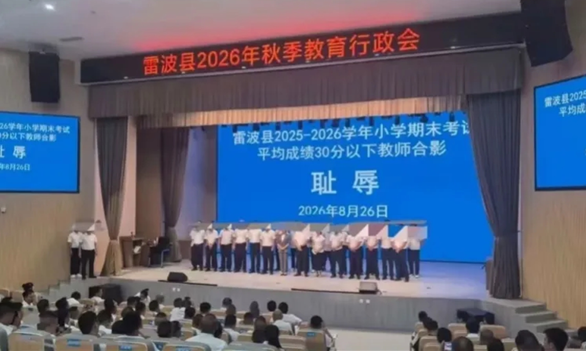 A photo from media reports shows teachers whose classes had an average score below 15 points standing before a backdrop bearing the Chinese characters for shame.