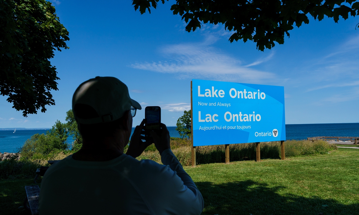 A person takes a picture of the newly unveiled sign for Lake Ontario at Fifty Point Conservation Area in Grimsby, Ontario, Canada, on Saturday, Aug. 29, 2026. Photo: VCG