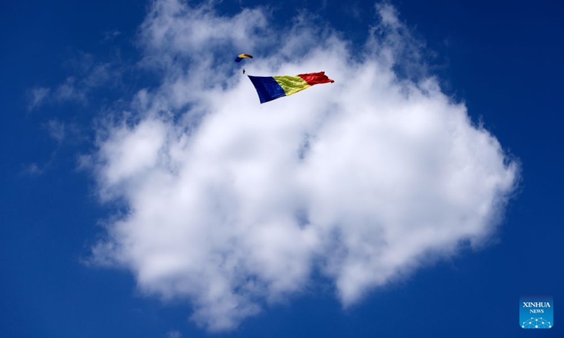 A Romanian parachutist flies with a large national flag during the Bucharest International Air Show 2026 in Bucharest, Romania, on Aug. 28, 2026. (Photo by Cristian Cristel/Xinhua)