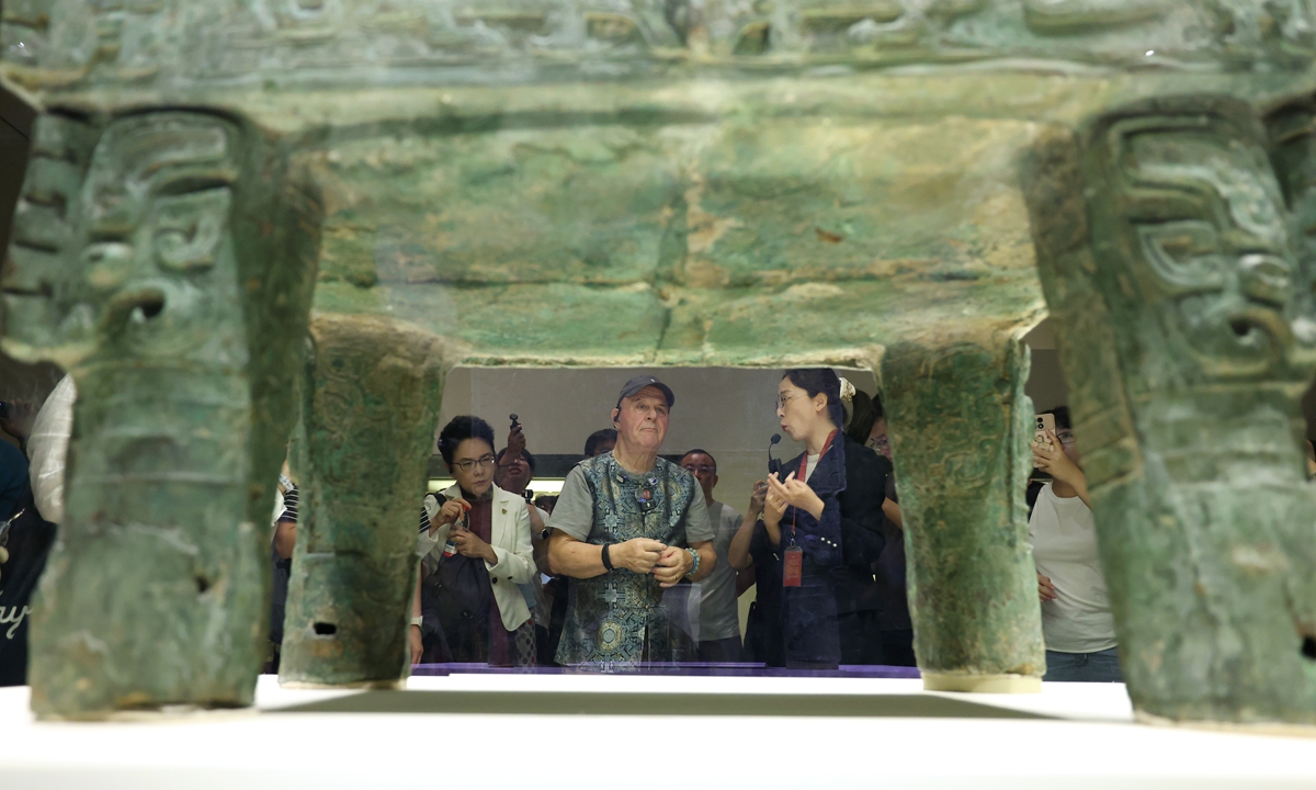 Retired US teacher Ronald Sakolsky (center) examines a bronze relic at the National Museum of China in Beijing on August 30, 2026. Twenty-six years after he came to China as an exchange teacher and raised funds to help fight desertification, Sakolsky is now on a new visit to China to reconnect with old friends and witness the green achievements his donation helped bring about. Photo: VCG