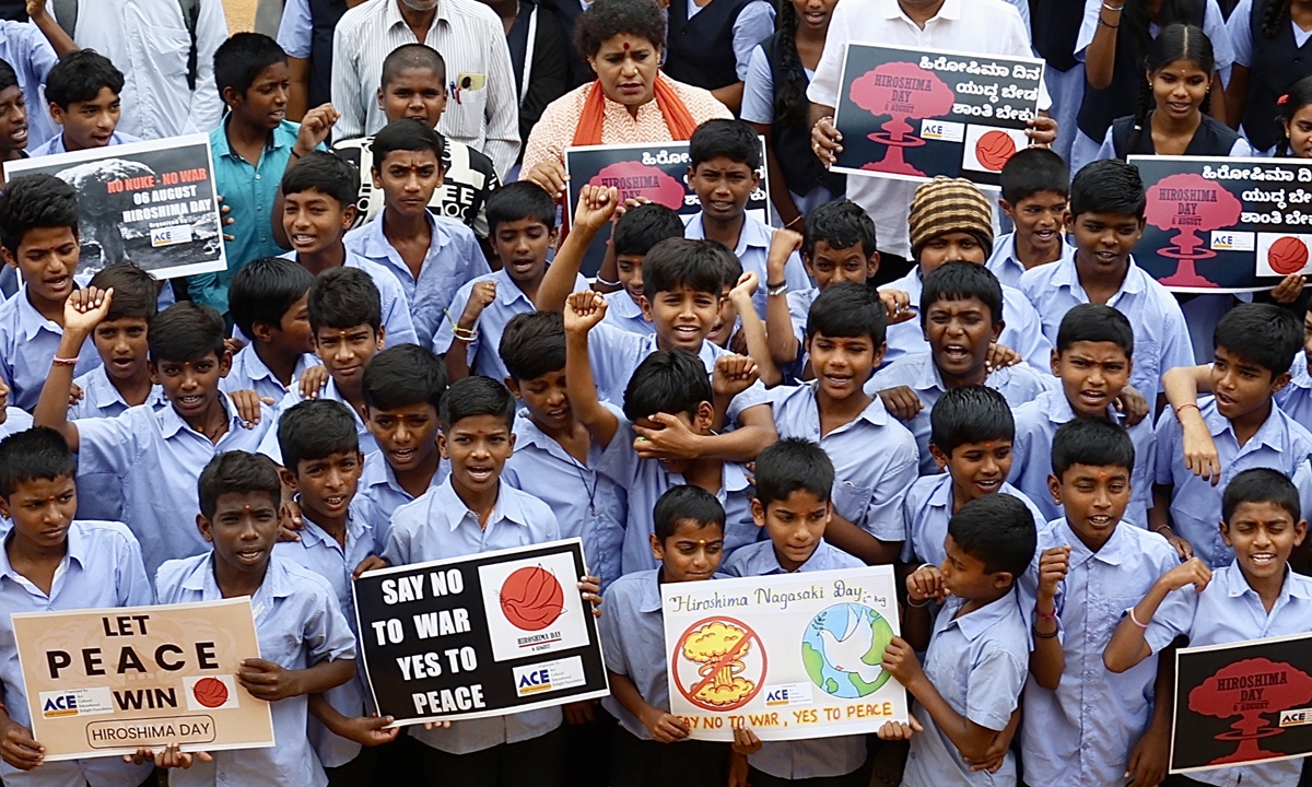 Schoolchildren hold placards to commemorate 